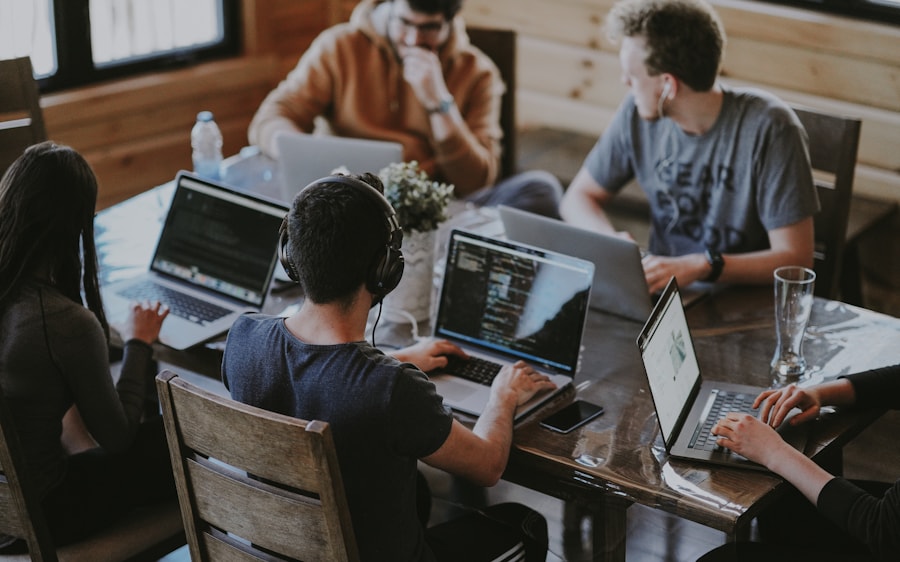 Diverse technology team collaborating with laptops in a bright open-plan office — how Metrion Infosolutions works with clients.
